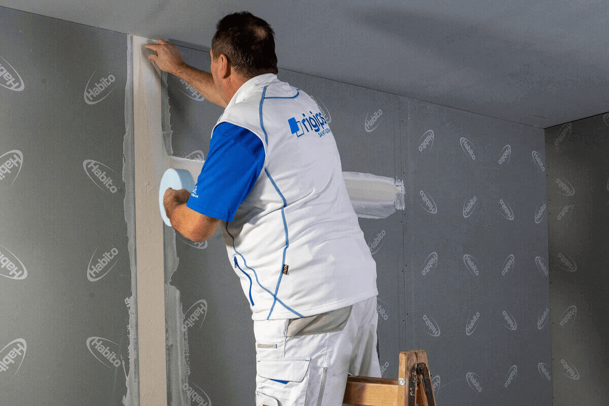 Na předtmelenou spáru naneseme vrstvu tmelu. Do této vrstvy vložíme Skelnou pásku Habito tak, aby hrubší síťovaná strana směřovala do stěny a jemnější fleecová strana do místnosti.